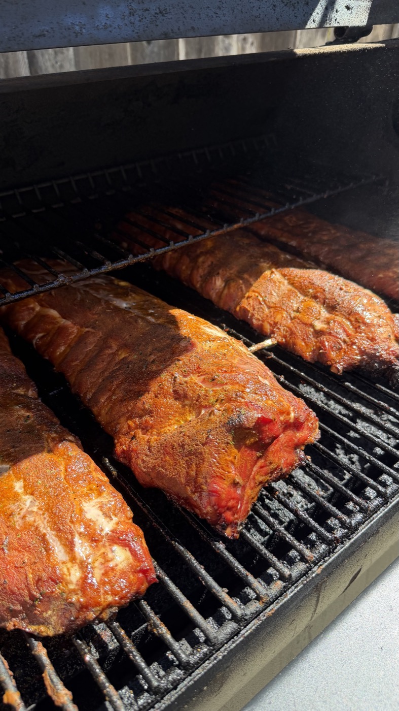 A rack of Miggy's Piggies ribs on the smoker